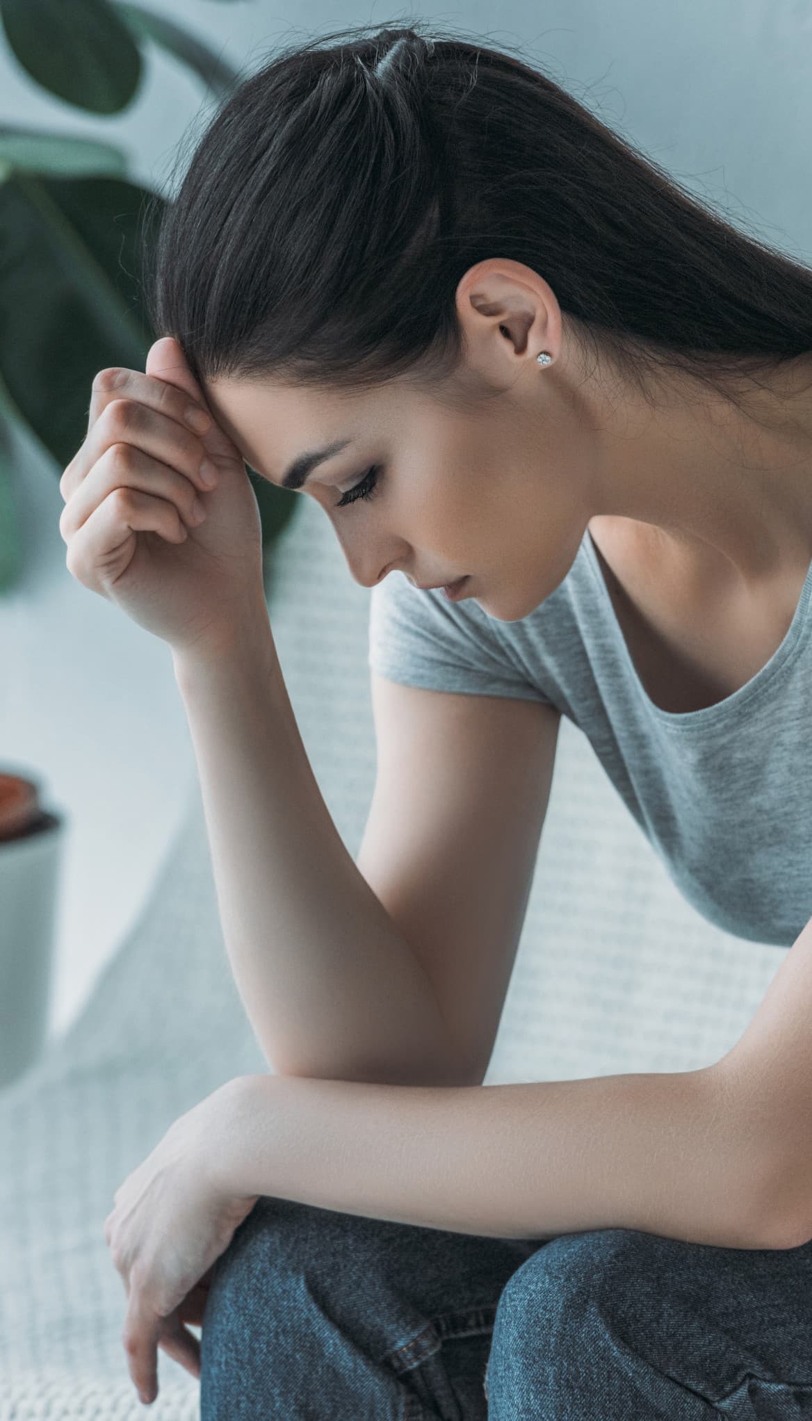 A pensive partner sitting alone on the couch, thinking